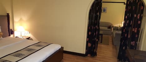 Una habitación de hotel con una cama, una mesita de noche, una lámpara, un sofá y una escalera.