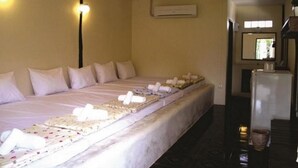 Una habitación de hotel con una cama grande, un refrigerador y aire acondicionado.