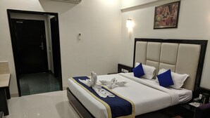 Una habitación de hotel con cama, mesita de noche, escritorio y silla.