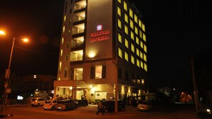 Un edificio de varios pisos con ventanas iluminadas y un cartel llamativo que dice "CHANDRA IMPERIAL".