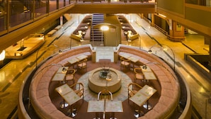 A spacious atrium with a central seating area, multiple levels with balconies, and a view of the cityscape through large windows. - Kagaya (Nanao)