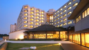 A modern hotel with multiple floors, a covered outdoor area, and a well-maintained lawn. - Aenokaze (Nanao)