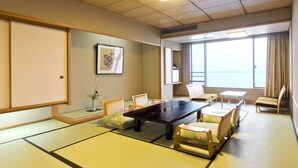 A traditional Japanese-style room with tatami flooring, a low table, and seating arrangements. - Aenokaze (Nanao)
