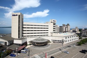 A modern hotel with a prominent tower and a round building with a dome-like structure. - Aenokaze (Nanao)