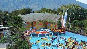 Parque acuático con zona de piscina temática de olas y estructura con temática de selva.