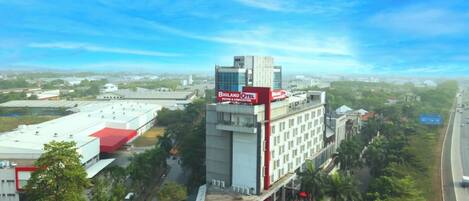 A hotel with a red and white facade, multiple floors, and a flat roof.
