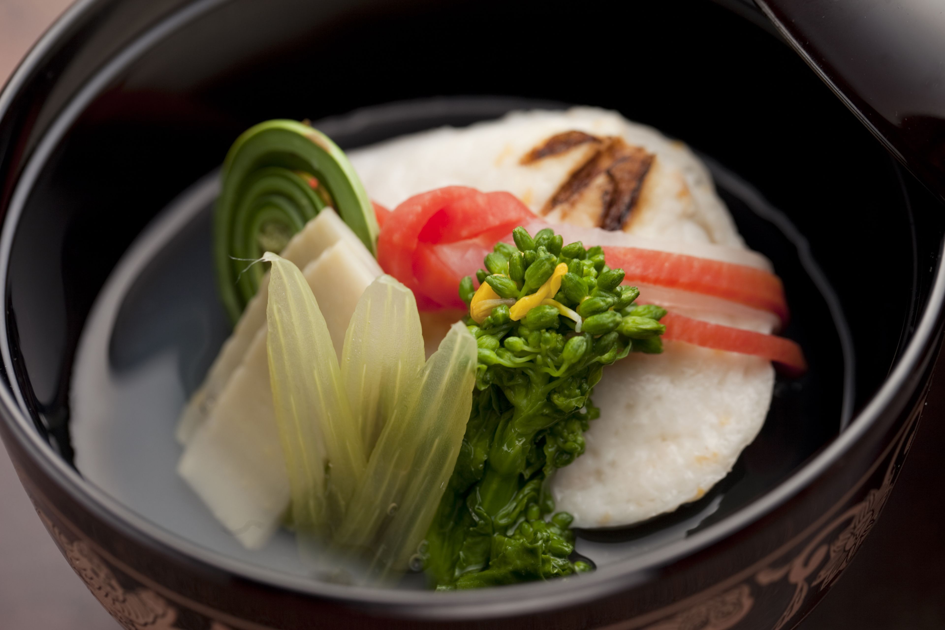 A bowl of food with rice, salmon, and vegetables.