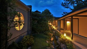 A modern building with a circular window, a pathway, and a small water feature. - Amane Resort Gahama (Beppu)