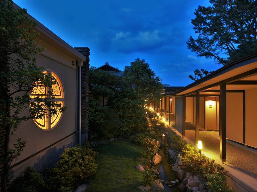A modern building with a circular window, a pathway, and a small water feature.
