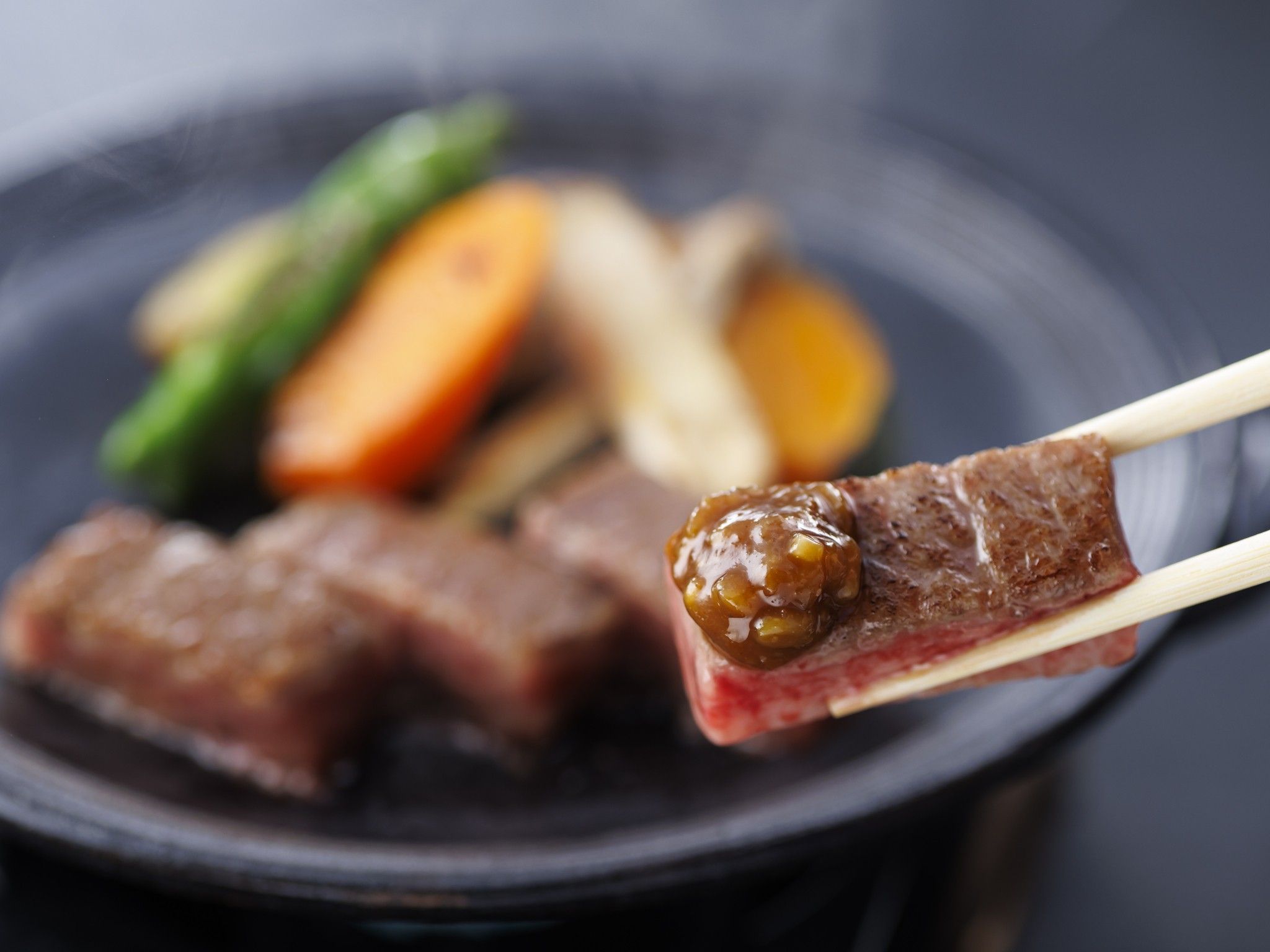 A close-up of a dish with meat and vegetables on a plate.