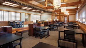 Een traditioneel Japans restaurant met houten balken, tatami zitplaatsen en hangende lantaarns van papier.