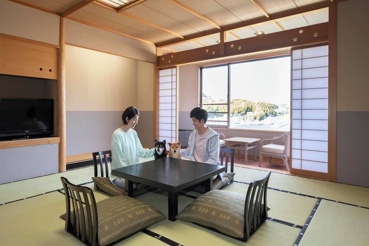 Ett traditionellt japanskt rum med tatamimattor på golvet, ett lågt bord och skjutdörrar.