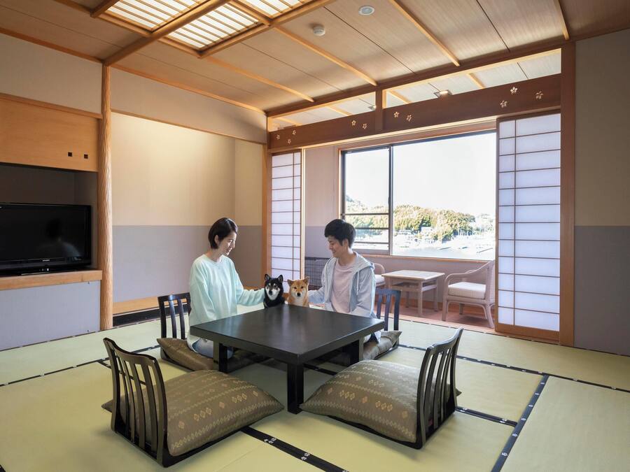 A traditional Japanese-style room with tatami flooring, a low table, and sliding doors.
