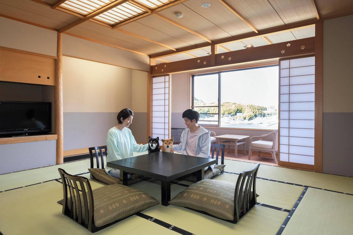 Ett traditionellt japanskt rum med tatamimattor på golvet, ett lågt bord och skjutbara shojidörrar.
