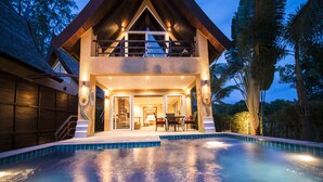 A two-story house with a swimming pool in front, a balcony, and a well-lit interior. - Villa Manipura (Ko Chang)