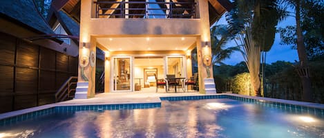 Vista frontal de la propiedad por la tarde o noche