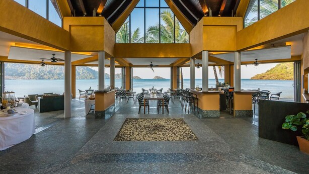 A spacious indoor area with a high ceiling, large windows, and a view of the sea. - Villa Manipura (Ko Chang)