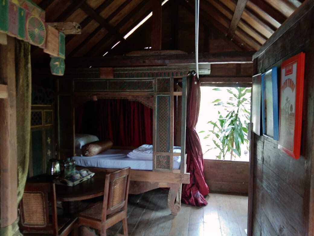 Una habitación rústica de madera con una cama, una mesa y sillas.