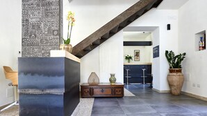 Un intérieur moderne avec une colonne en métal foncé, un meuble en bois et un escalier.