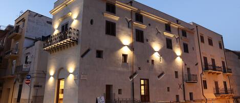 A multi-story building with balconies and illuminated windows, suggesting a hotel or residential complex.