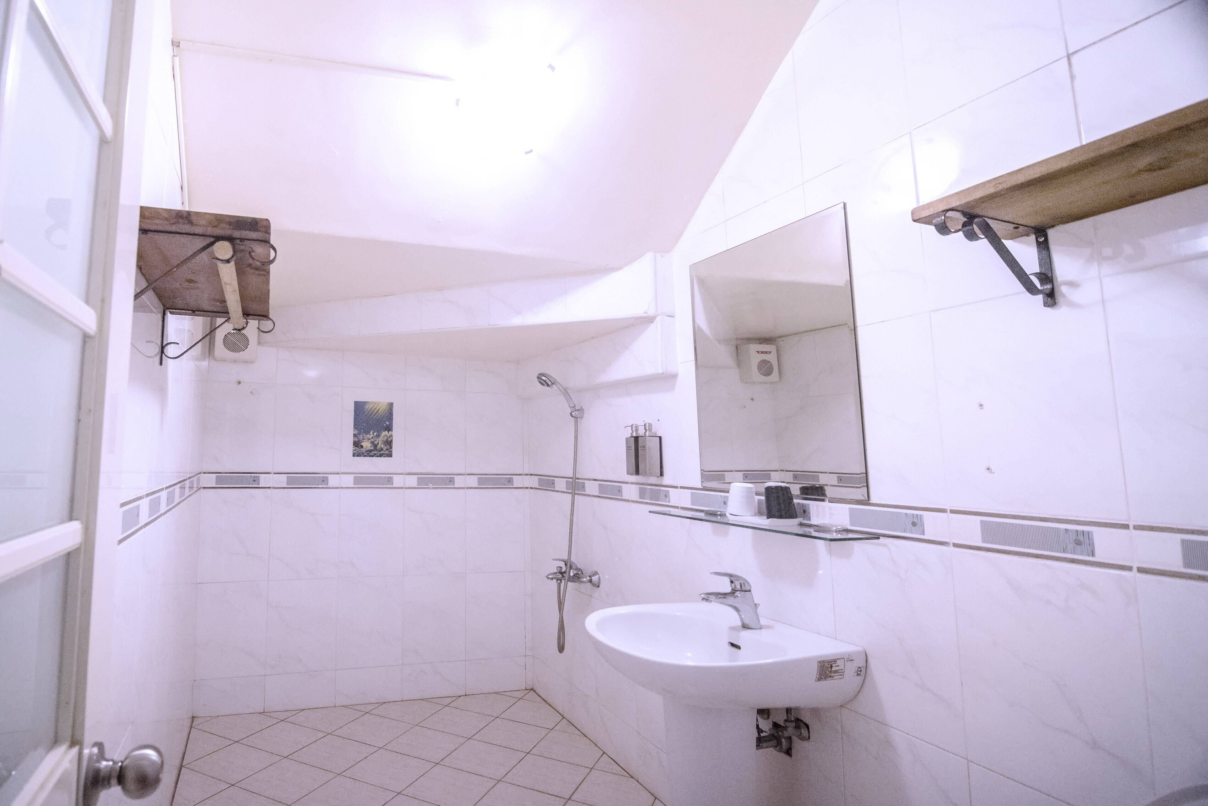 Une salle de bain avec une douche, un lavabo et un miroir.