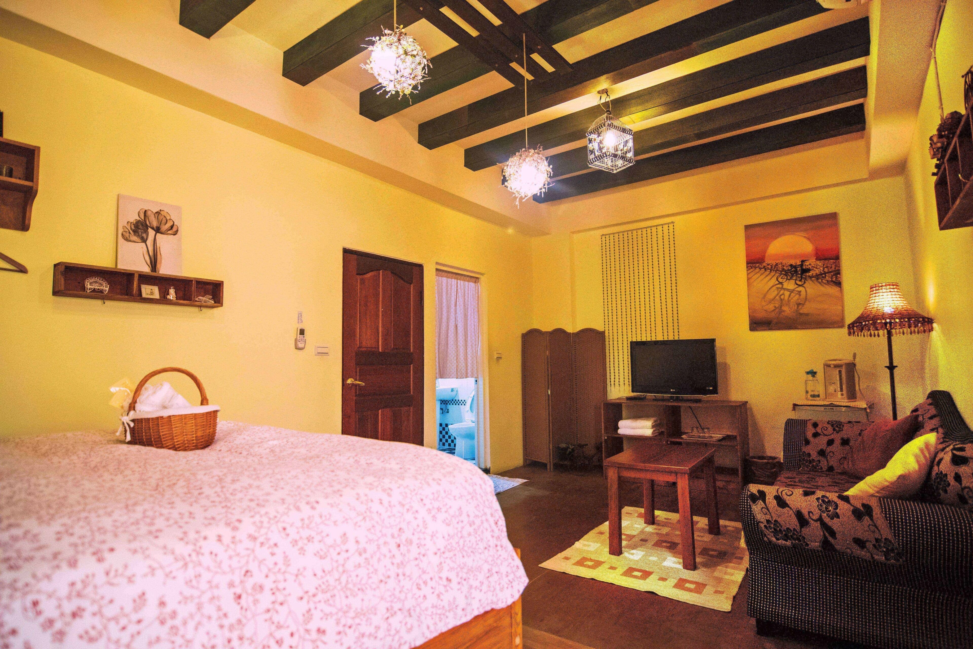 Uma sala de estar acolhedora com uma cama grande, uma televisão e um sofá.