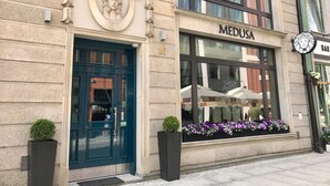 A building with a blue door, a sign reading "MEDUSA", and a window display with flowers. - Medusa Gdańsk (Gdansk)