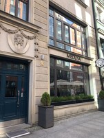 Un edificio con una porta blu, un cartello con scritto "MEDUSA" e il numero "16" sopra la porta.