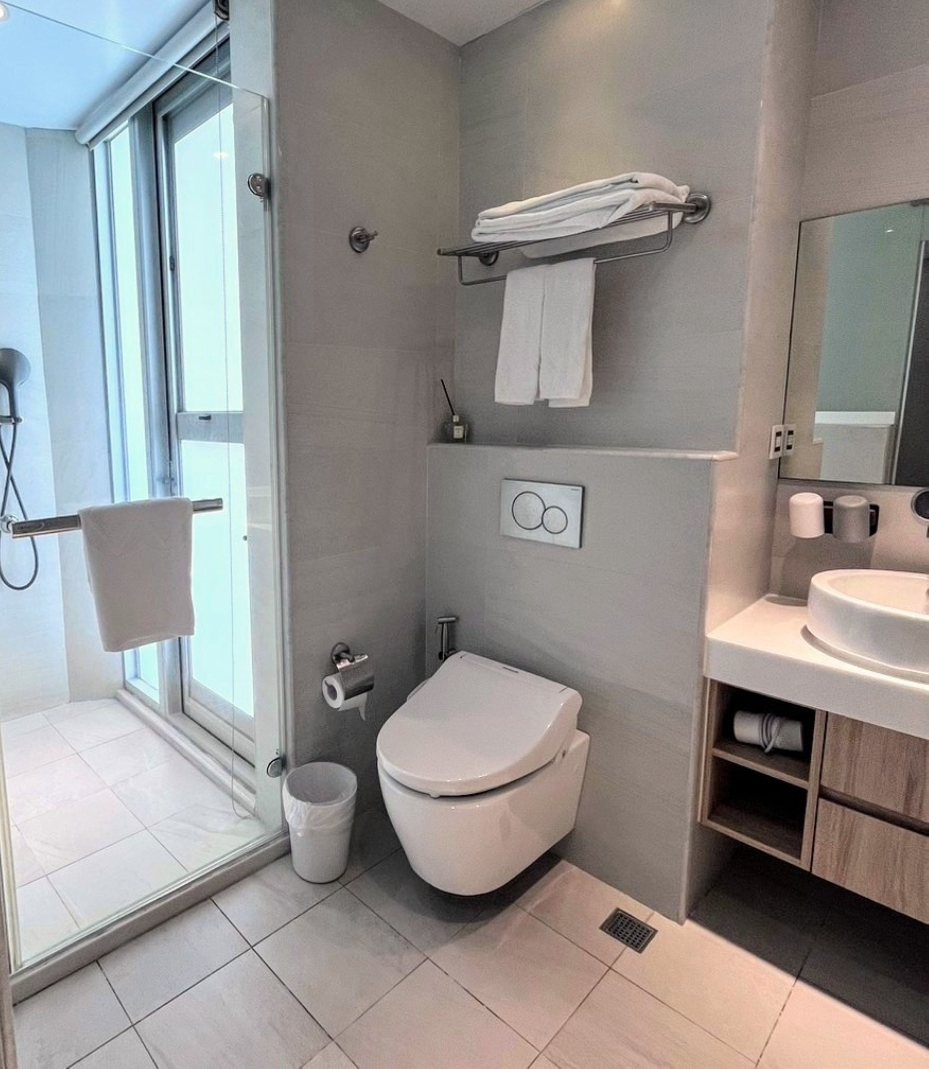 A modern bathroom with a toilet, sink, and shower area.