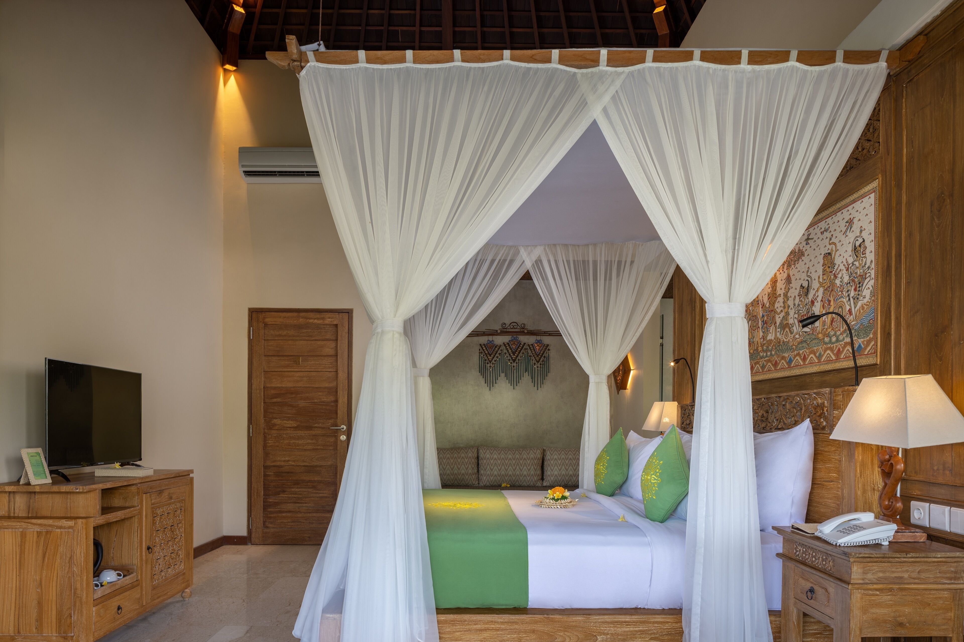 A bedroom with a four-poster bed, a television on a wooden cabinet, and a nightstand with a lamp.