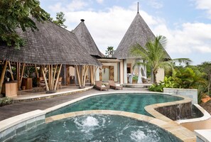 A resort with a pool, bamboo structures, and a waterfall. - The Alena Resort A Pramana Experience (Ubud)