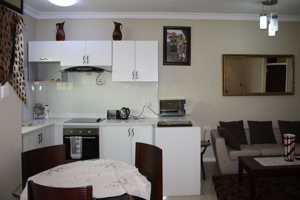 Un espacio habitable compacto con kitchenette, comedor y zona de estar.