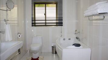 A bathroom with a bathtub, toilet, and sink.