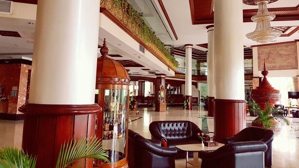 A spacious lobby with high ceilings, ornate columns, and a grand chandelier. - Oattara Thiri Hotel (Oattara Thiri Township)