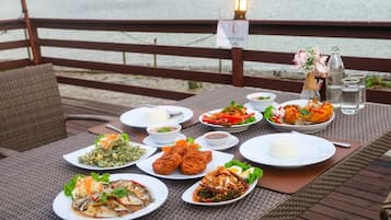 A table set with various dishes, a sign indicating a no-leaning policy, and a lamp post in the background.