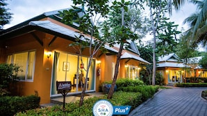 A hotel with a well-lit entrance, a sign indicating it is a Thai property, and a logo for 'SHA Plus+'. - Baan Amphawa Resort & Spa (Amphawa)