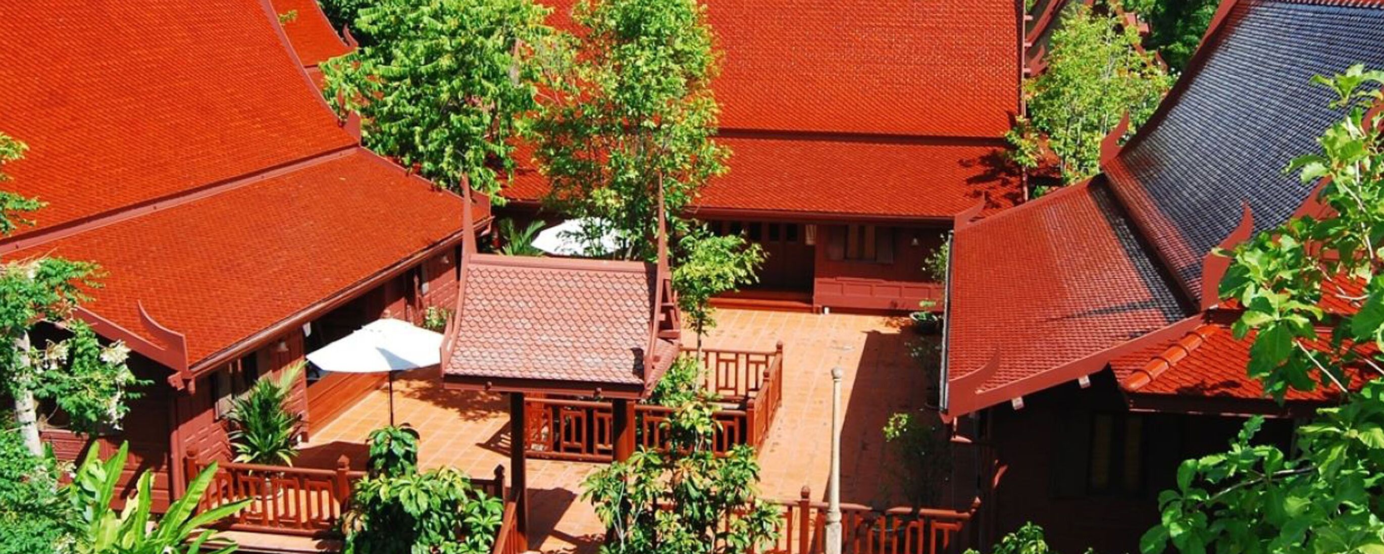 Un edificio tradicional con varios tejados de tejas rojas y balcones de madera.