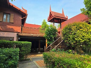 A traditional building with a red roof and a covered walkway. - Baan Amphawa Resort & Spa (Amphawa)