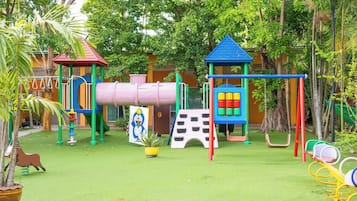 Un parque infantil con diversas estructuras de juego, como toboganes, columpios y escaleras.