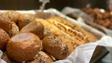 Diversidade de pães e doces expostos em uma padaria.