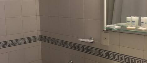 A bathroom with a bidet, toilet, sink, and a mirror with a shower curtain reflection.