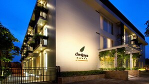A modern hotel with a white facade, a logo with a leaf, and balconies with plants. - Dwijaya House of Pakubuwono (Jakarta)