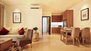 A modern living room with a sofa, armchairs, a coffee table, and a dining area with a table and chairs. - Dwijaya House of Pakubuwono (Jakarta)