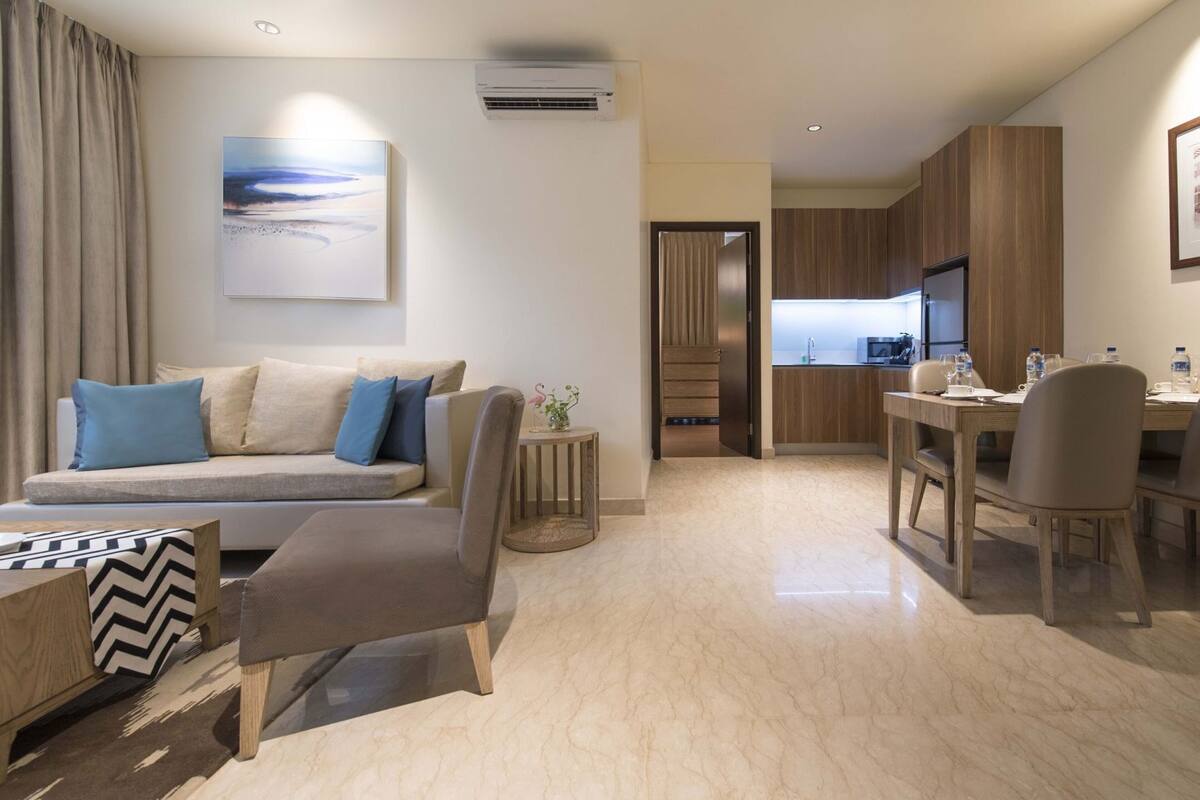 Una sala de estar moderna con un sofá, una mesa de comedor y una zona de cocina.