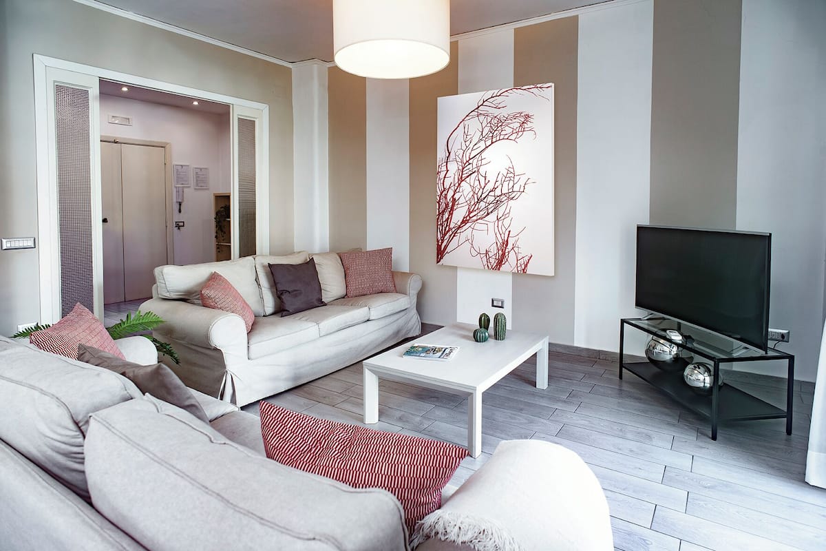 Una sala de estar moderna con sofá, mesa de centro y televisor.