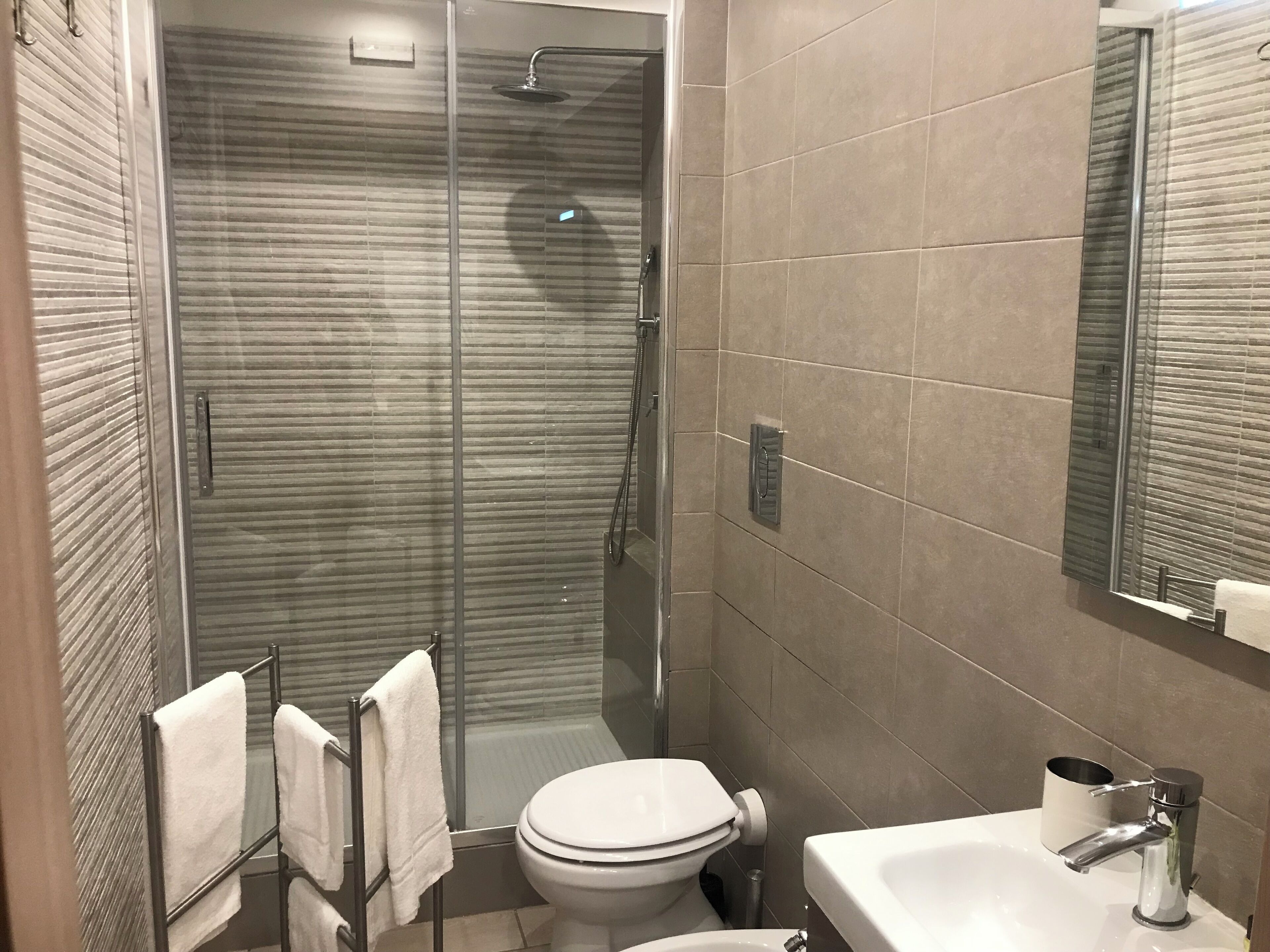 Ein modernes Badezimmer mit einer Duschkabine, einer Toilette und einem Waschbecken.