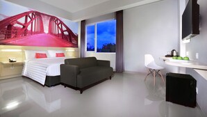 A modern hotel room with a bed, a sofa, a desk, and a TV. - favehotel Sudirman Bojonegoro (Bojonegoro)