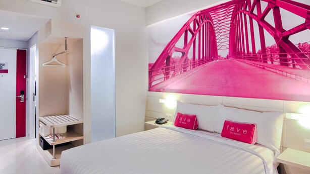 A modern hotel room with a bed, a wardrobe, a hanging rack, and a large wall mural of a bridge. - favehotel Sudirman Bojonegoro (Bojonegoro)