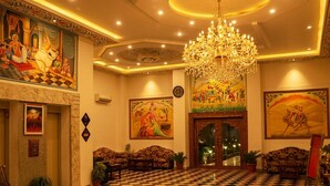 A lobby with checkered flooring, a chandelier, and artwork on the walls. - Amer City Heritage Hotel (Jaipur)