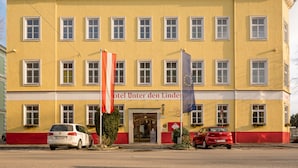 Un bâtiment jaune avec de nombreuses fenêtres et une enseigne indiquant « Hôtel Unter den Linden ».